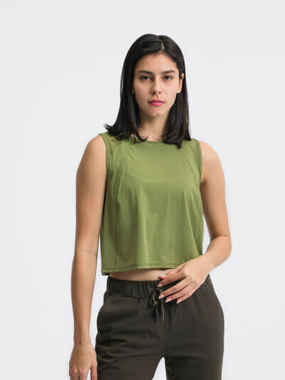 Model wearing a Millennia Round Neck Cropped Active Tank in olive green, showcasing its cropped design and stretch fabric.