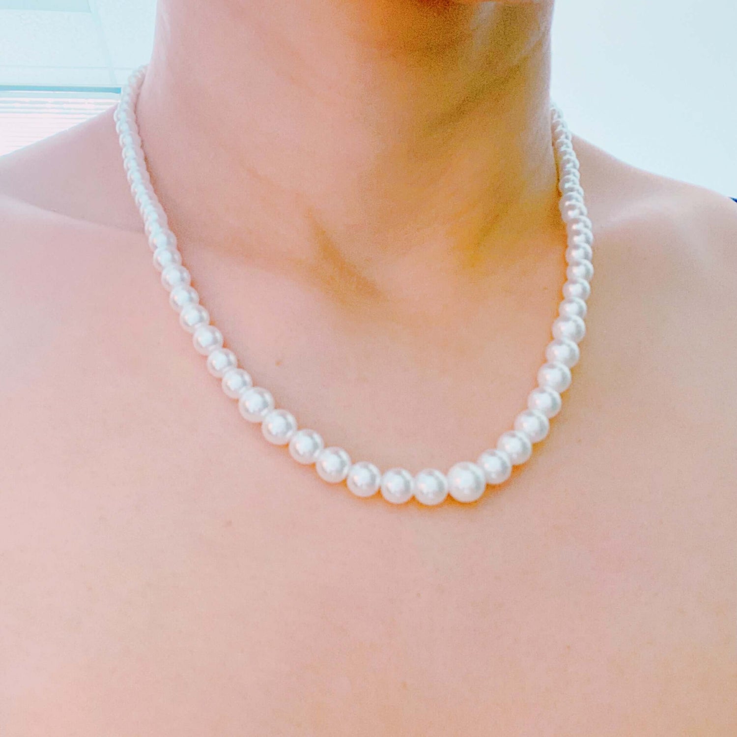 Graduated pearl necklace featuring cream-toned glass pearls, 18" long with a 2" extender, elegant and timeless design.