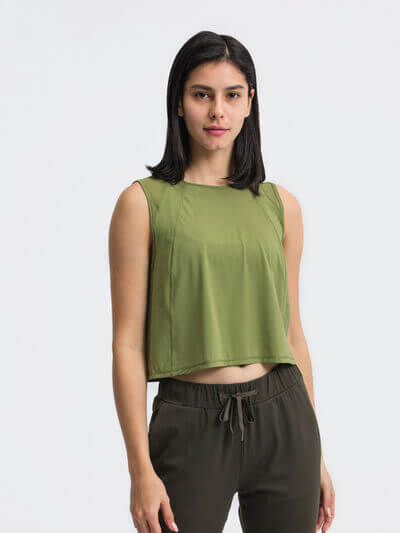 Model wearing a green cropped active tank top with round neck design, perfect for workouts and casual wear.