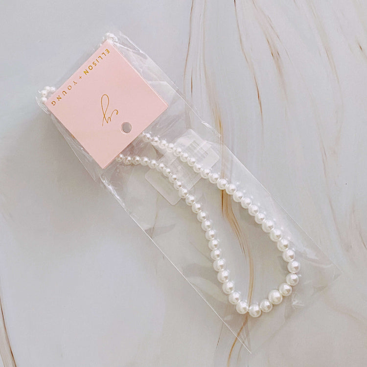 Graduated cream pearl necklace in packaging, showcasing elegant design and 18k gold-plated detail.