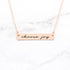Choose Joy rose gold quote bar necklace with inspirational message on a marble background.