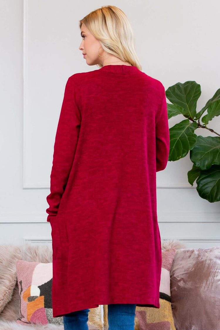 Back view of a woman wearing a soft, brushed red cardigan with long sleeves and pockets.