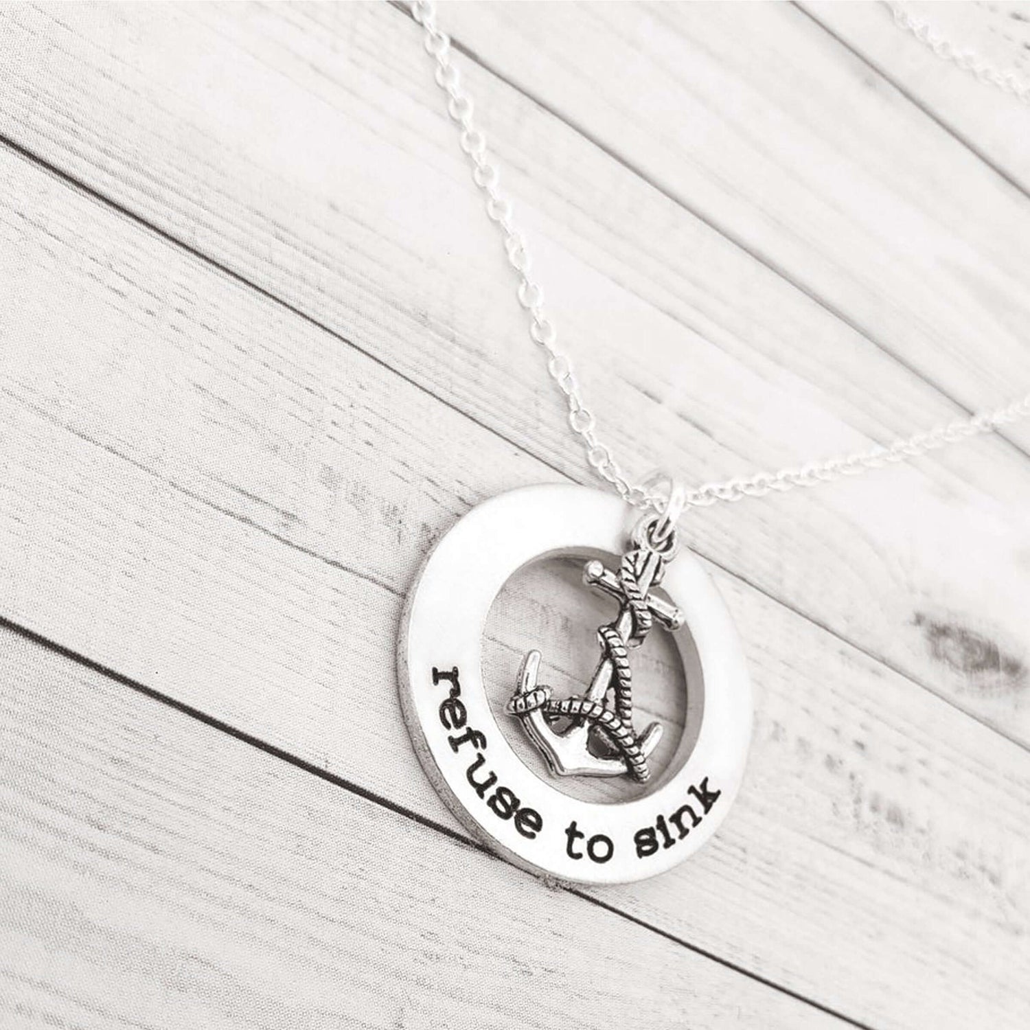 Hand-stamped refuse to sink washer necklace with anchor charm on an 18-inch chain, ideal gift for encouragement.