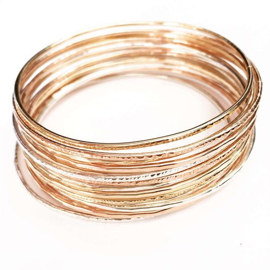 Robyn Bangle set featuring stacked metal bracelets in gold, rose gold, and silver tones, ideal for any occasion.