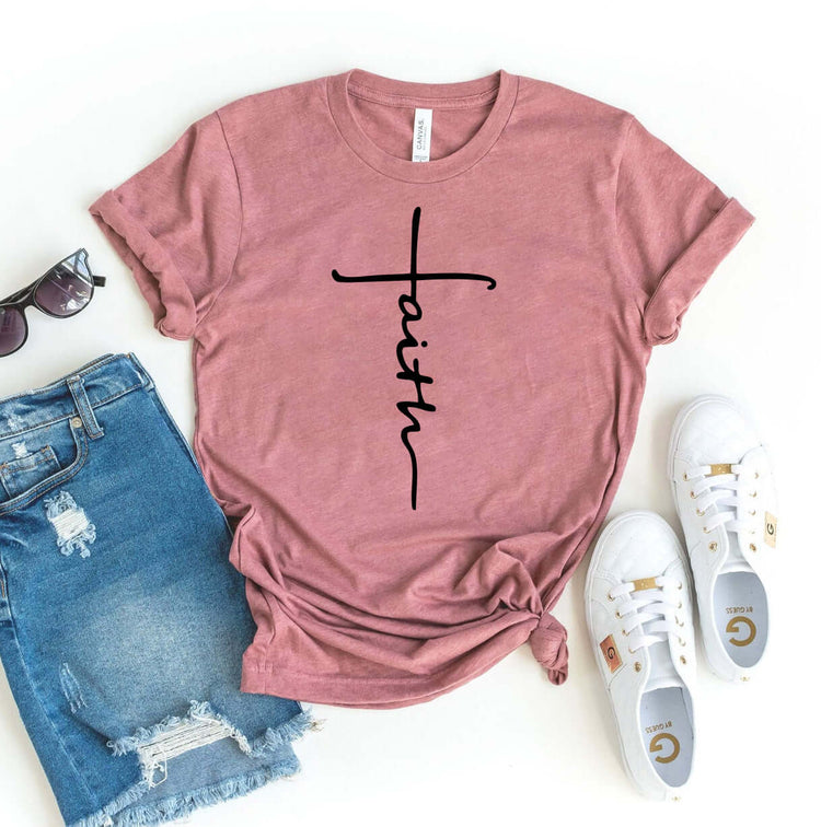 Rose pink Faith T-Shirt made of premium cotton, featuring stylish text design, paired with denim shorts and white sneakers.