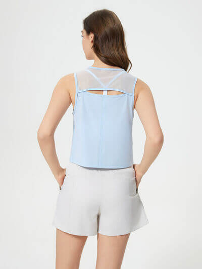 Back view of Millennia round neck cropped active tank in light blue, paired with shorts, showcasing sheer details.