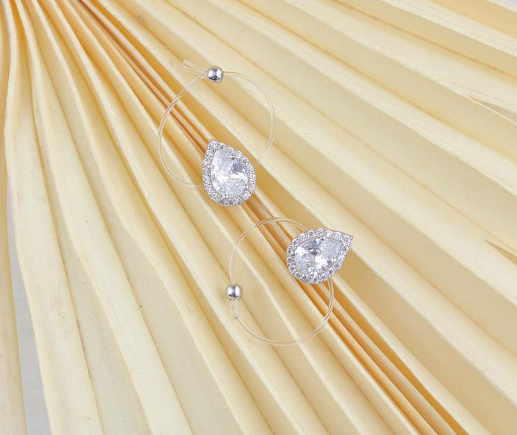 Sterling silver floating pear shaped ring featuring sparkling cubic zirconia on clear cord, ideal for arthritic hands.