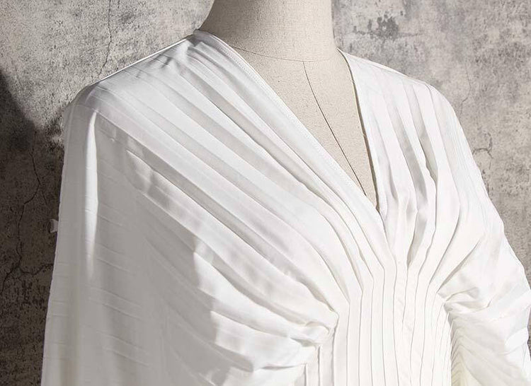 Sakiya pleated long sleeve shirt dress in white showcasing V-neck and stylish pleats, perfect for casual occasions.