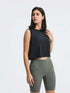 Model wearing Millennia Round Neck Cropped Active Tank in black, paired with green workout shorts.
