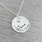 Personalized sterling silver necklace with two discs and heart charm, featuring names hand-stamped on the pendants.