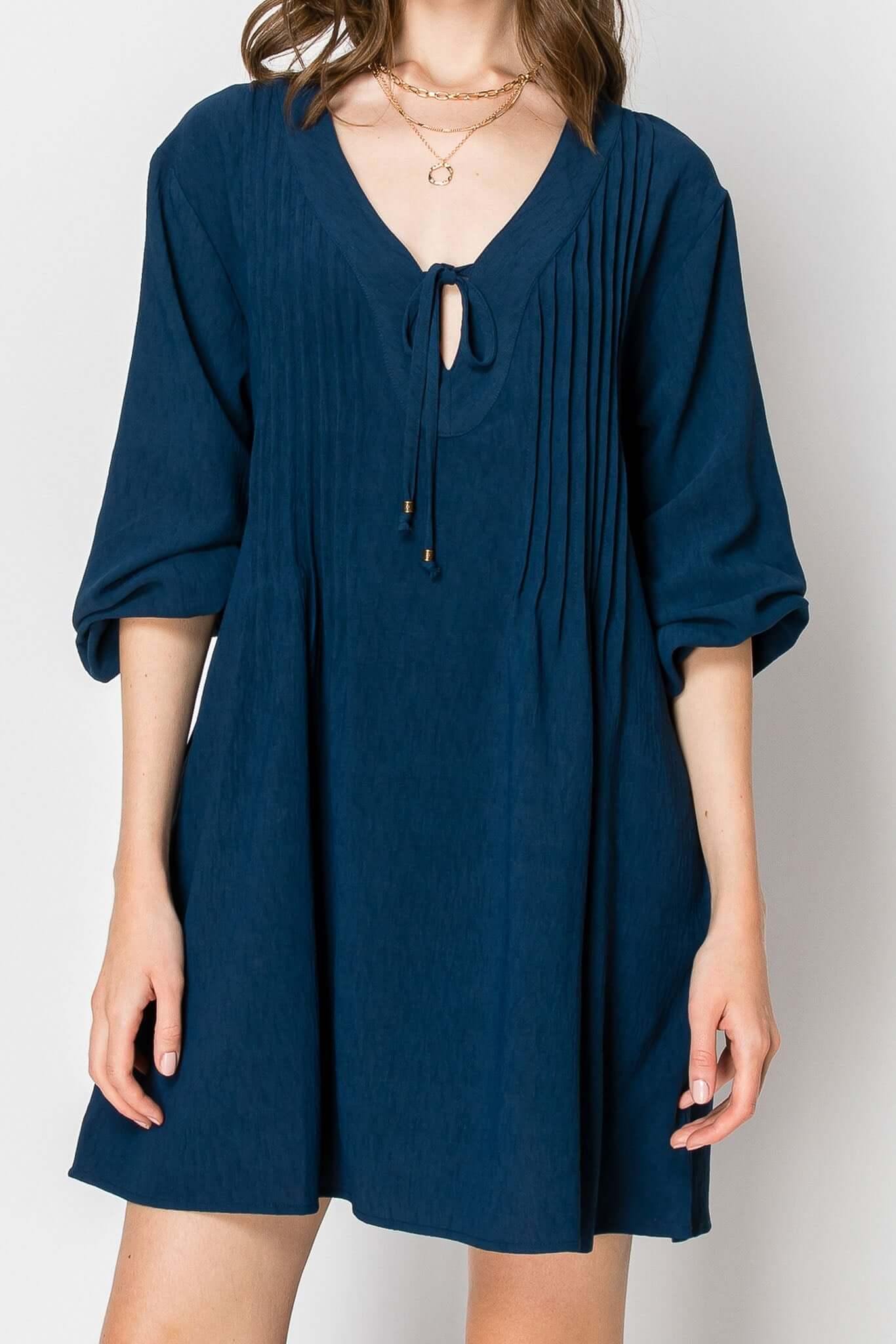 Long sleeve pintuck A-line dress in navy with front tie and pockets, perfect for casual fall wear.