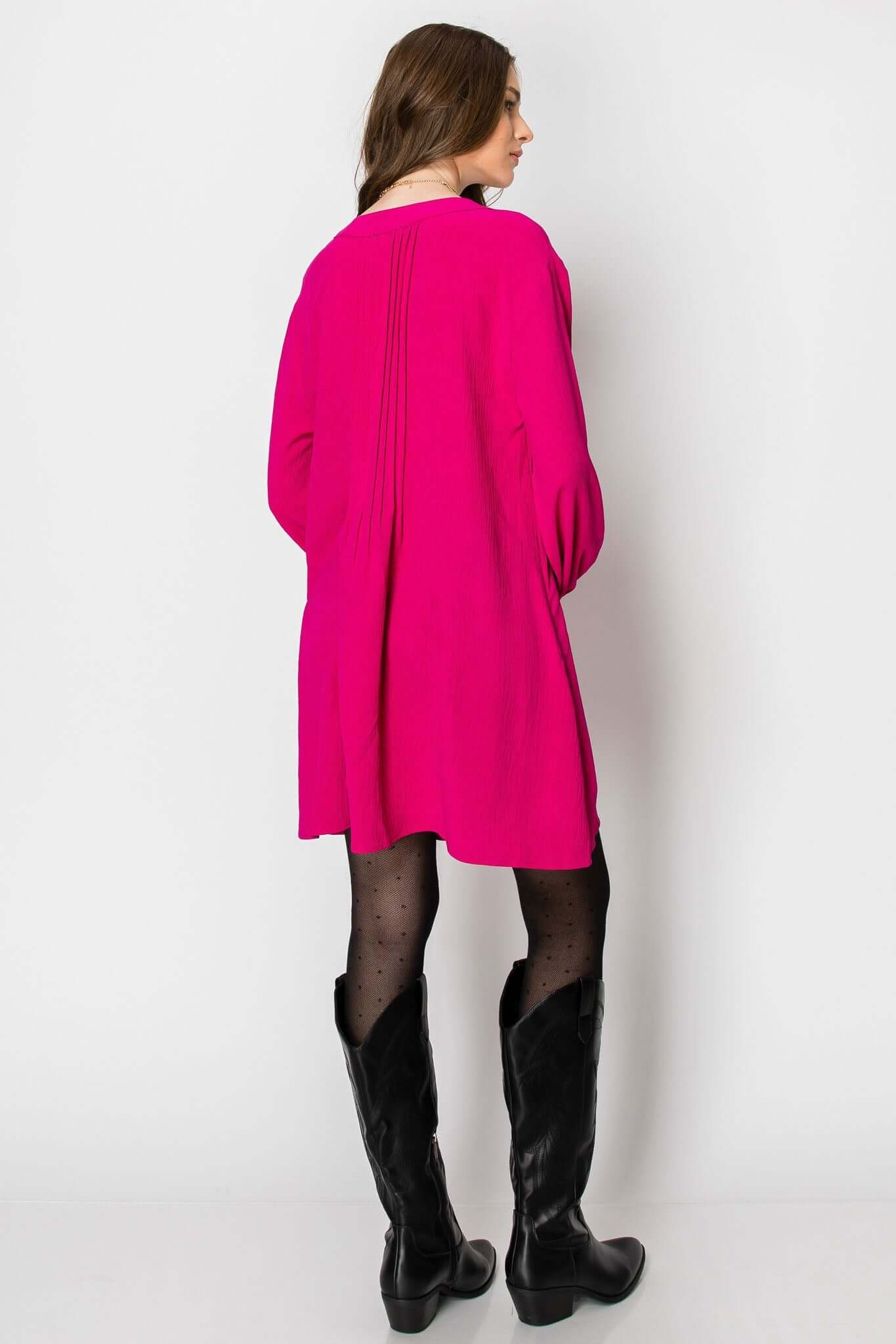 Back view of long sleeve hot pink A-line dress with pintuck detail, perfect for casual fall wear with boots.