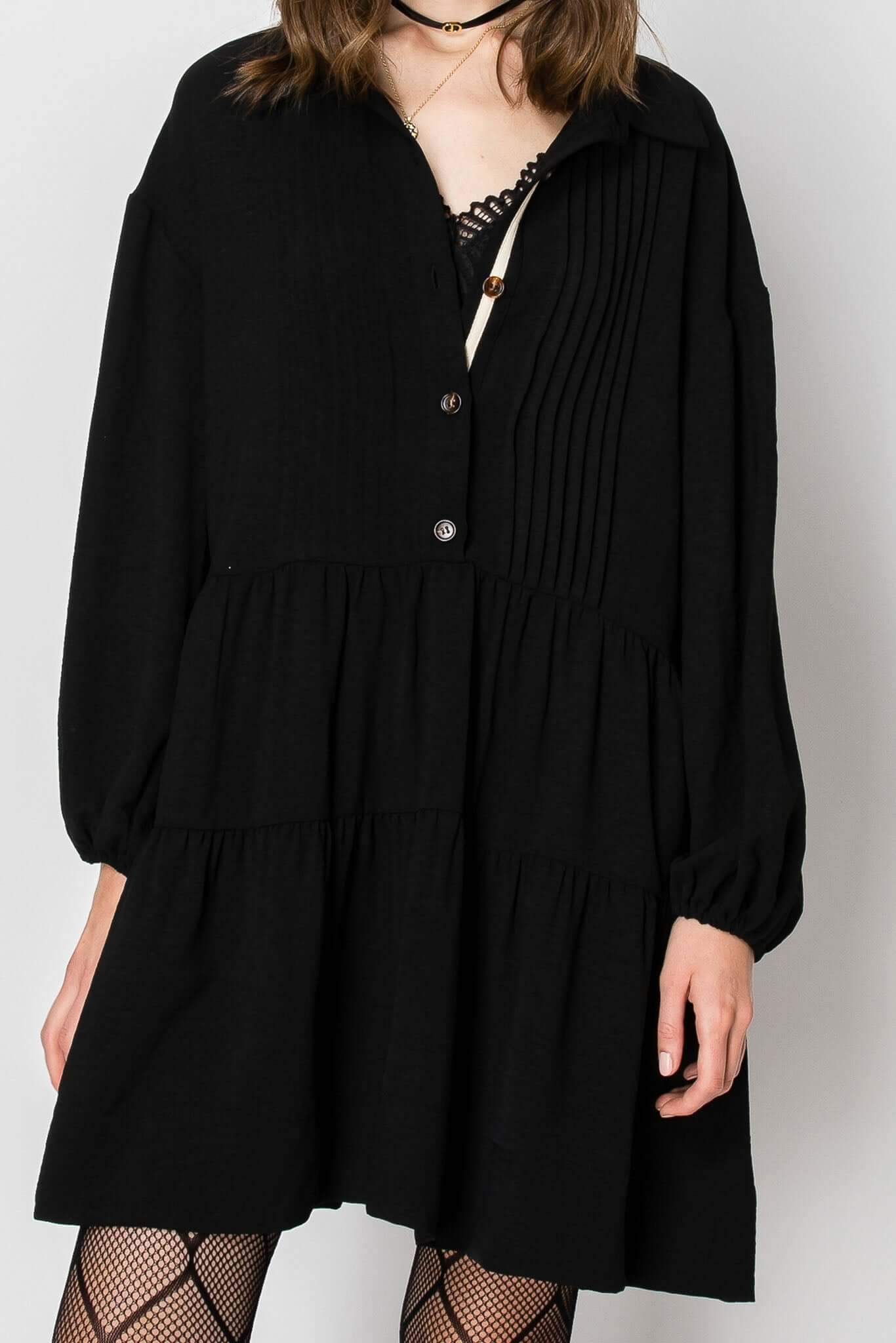 Long sleeve collared button-down tiered ruffle dress in black, featuring a flowy baby doll silhouette with contrast trim.