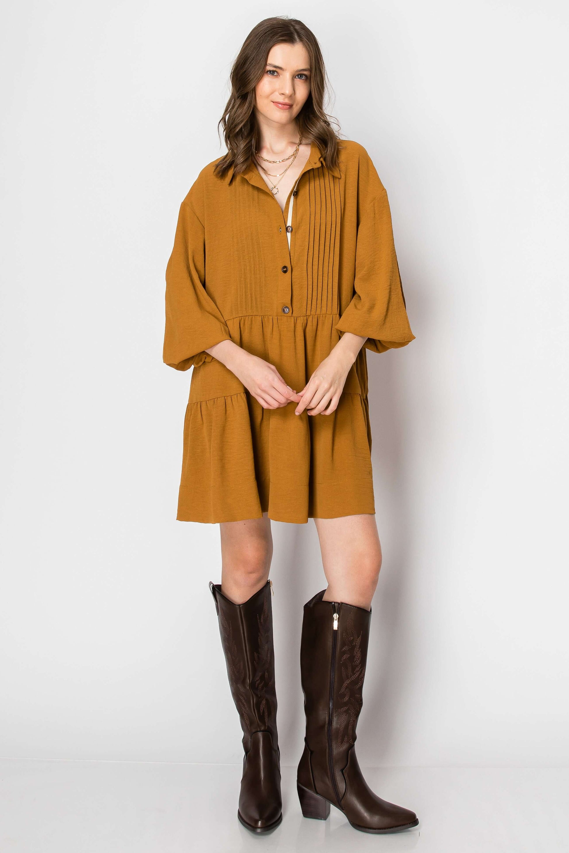 Long sleeve collared tiered ruffle baby doll dress in mustard, styled with knee-high brown western boots.