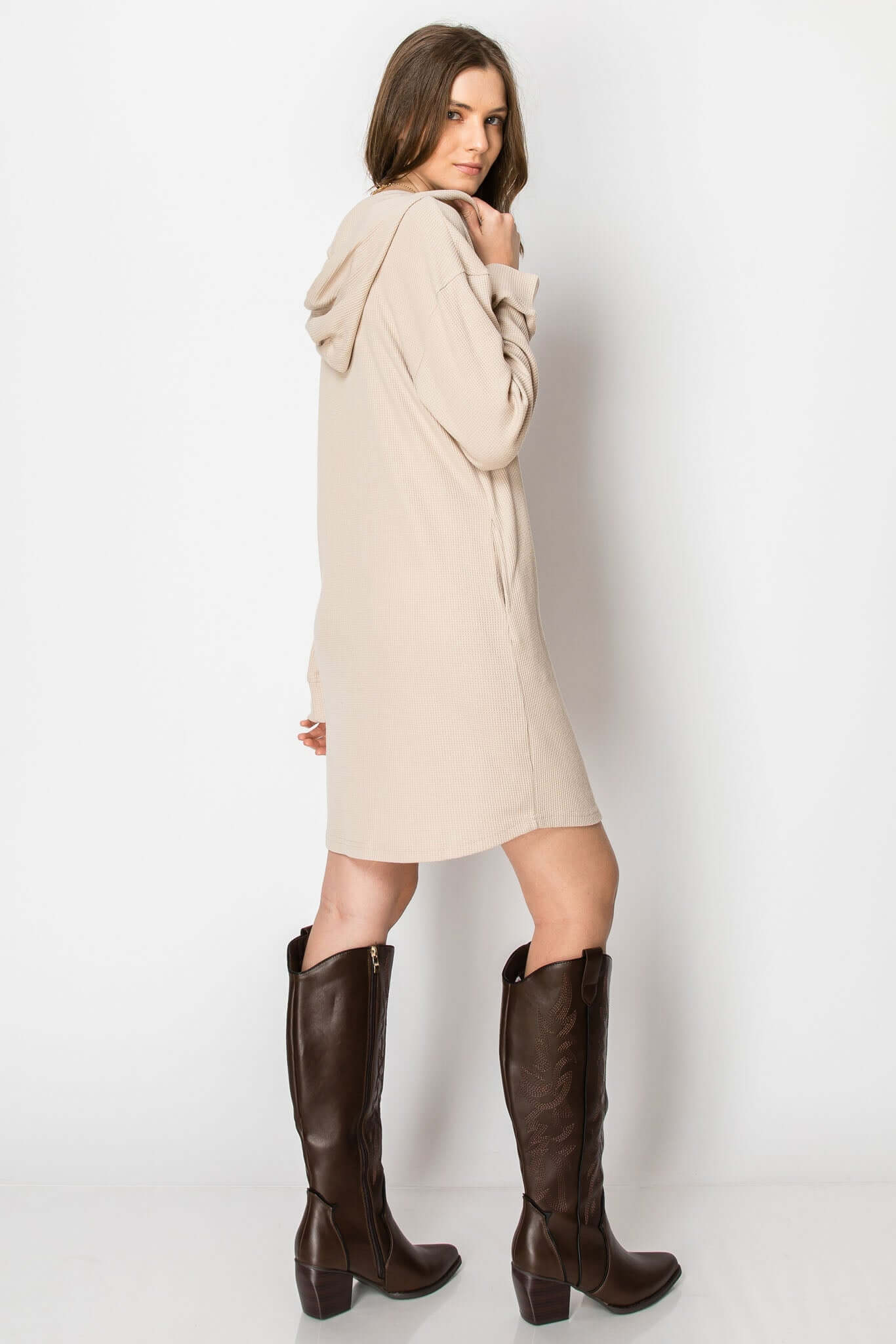 Woman wearing a beige waffle knit long sleeve button down hoodie dress with pockets, styled for casual fall layering.