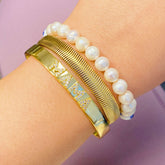 Mama open bangle bracelet with shiny CZs and pearl accents, 18k gold plated on a wrist.