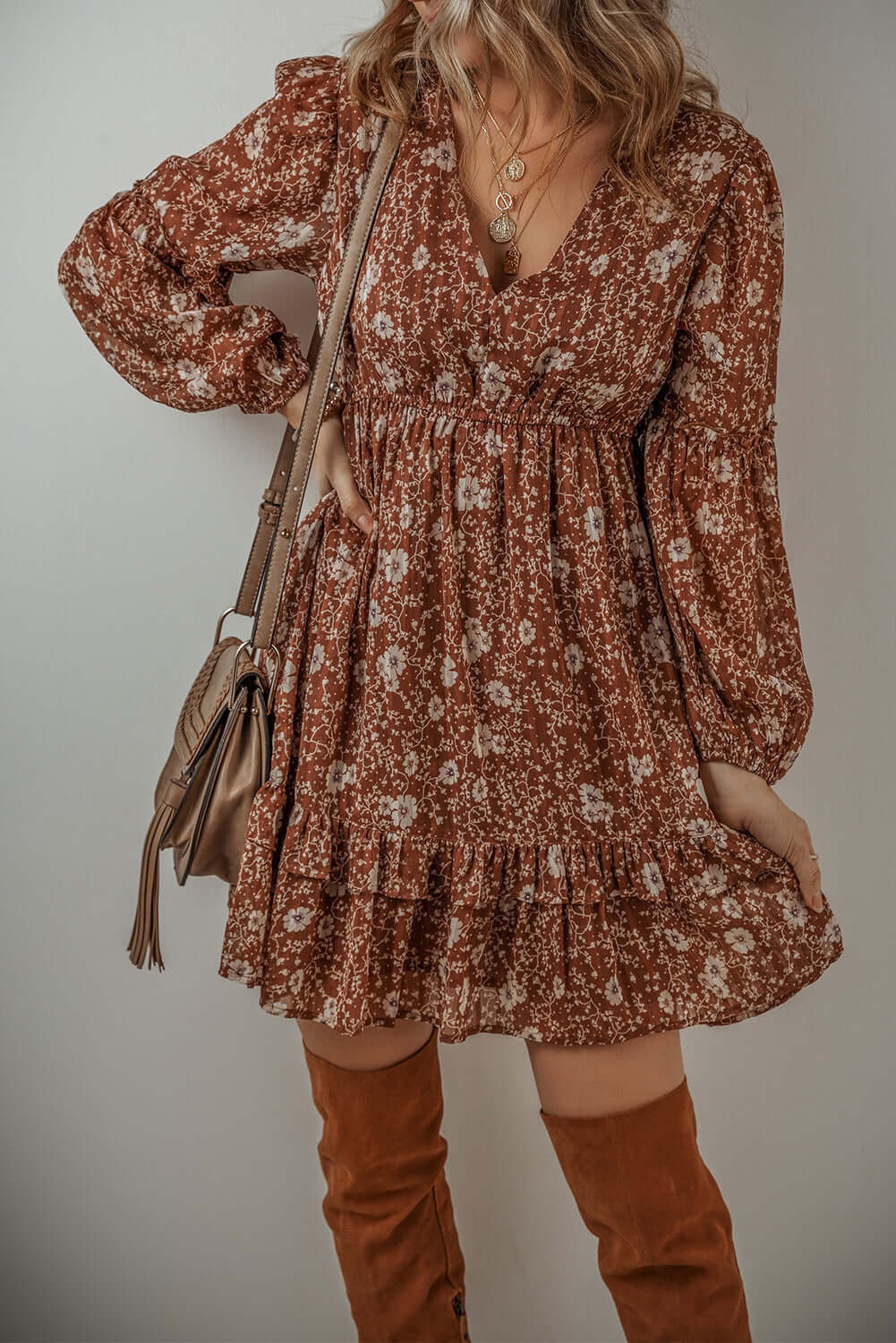 Ashley Boho Floral Puff Sleeve Mini Dress with ruffles, V-neckline, and floral pattern, styled with knee-high boots.