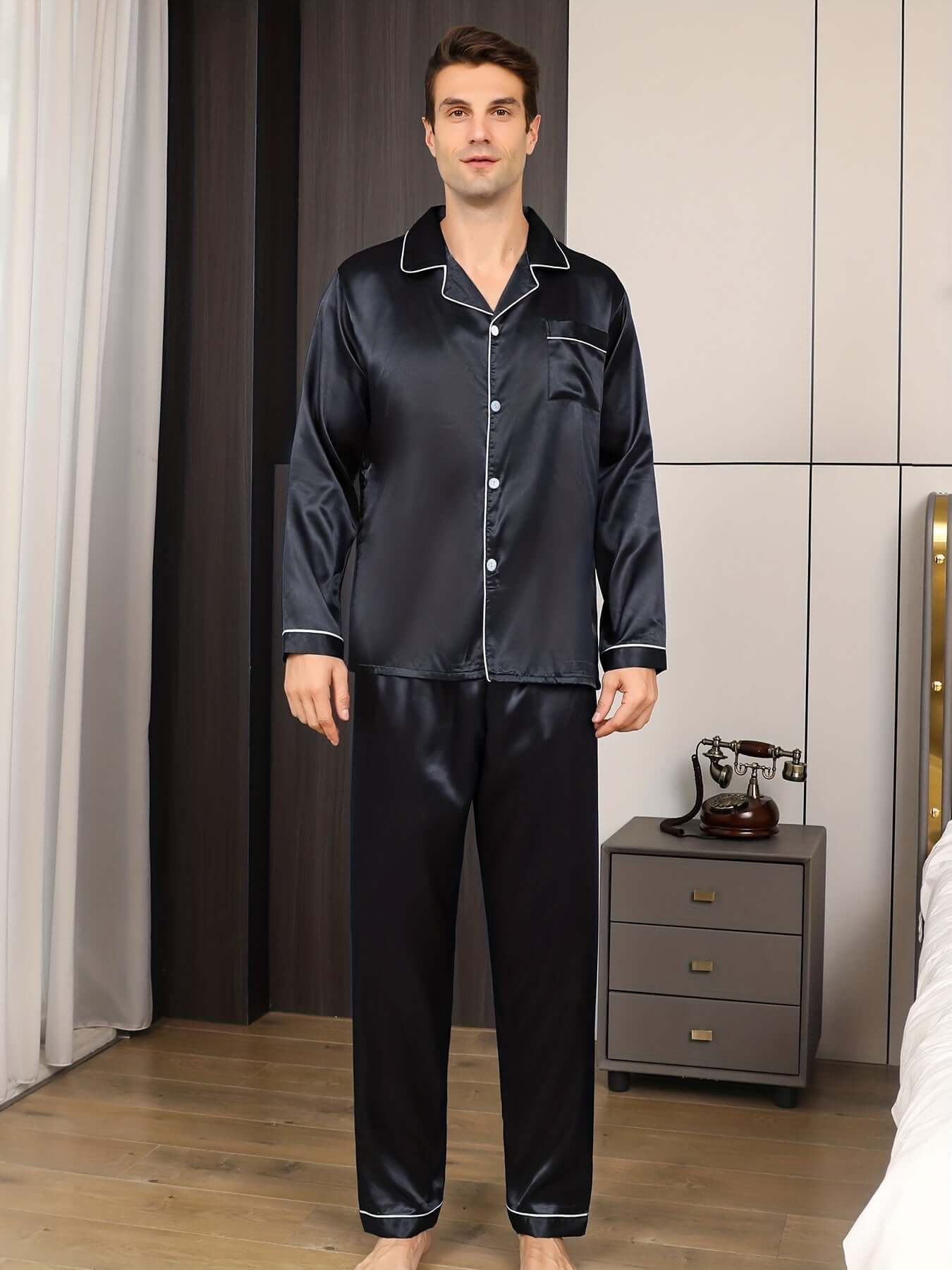 Man in elegant black ice silk pajama set with long sleeves and pants, perfect for stylish loungewear.