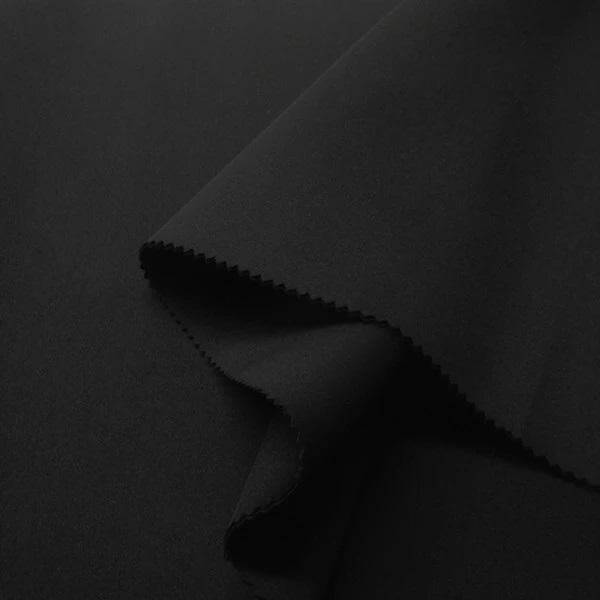 Close-up of smooth black neoprene fabric, ideal for evening dresses and fashion design.