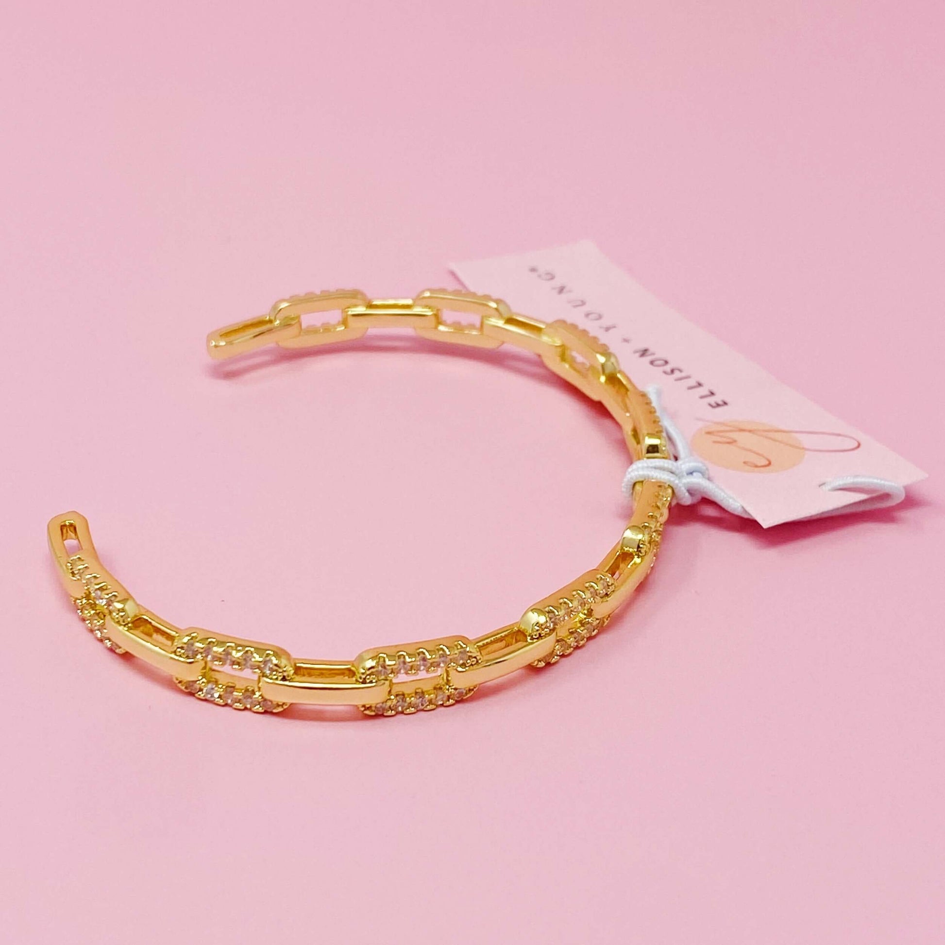 Stylish alternatively linked open bangle bracelet in 18k gold plated brass with cubic zirconia, adjustable fit.