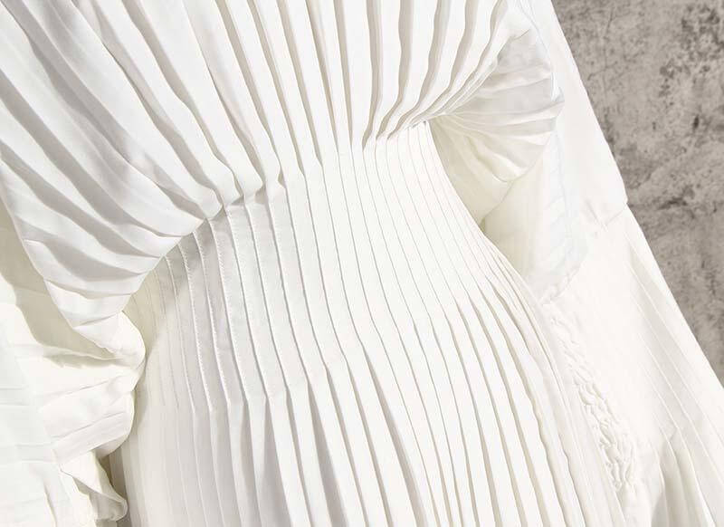 Close-up of the pleated design on the Sakiya Long Sleeve Shirt Dress in white, showcasing elegant cotton texture.