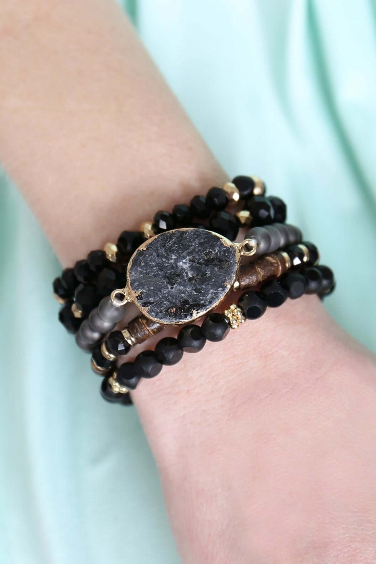 Natural stone charm mixed beads bracelets stacked on a wrist, showcasing intricate details and a stylish design.