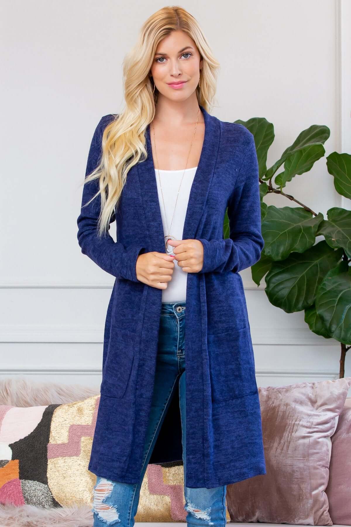 Model wearing a navy brushed sweater pocket cardigan, styled with skinny jeans and a white top.