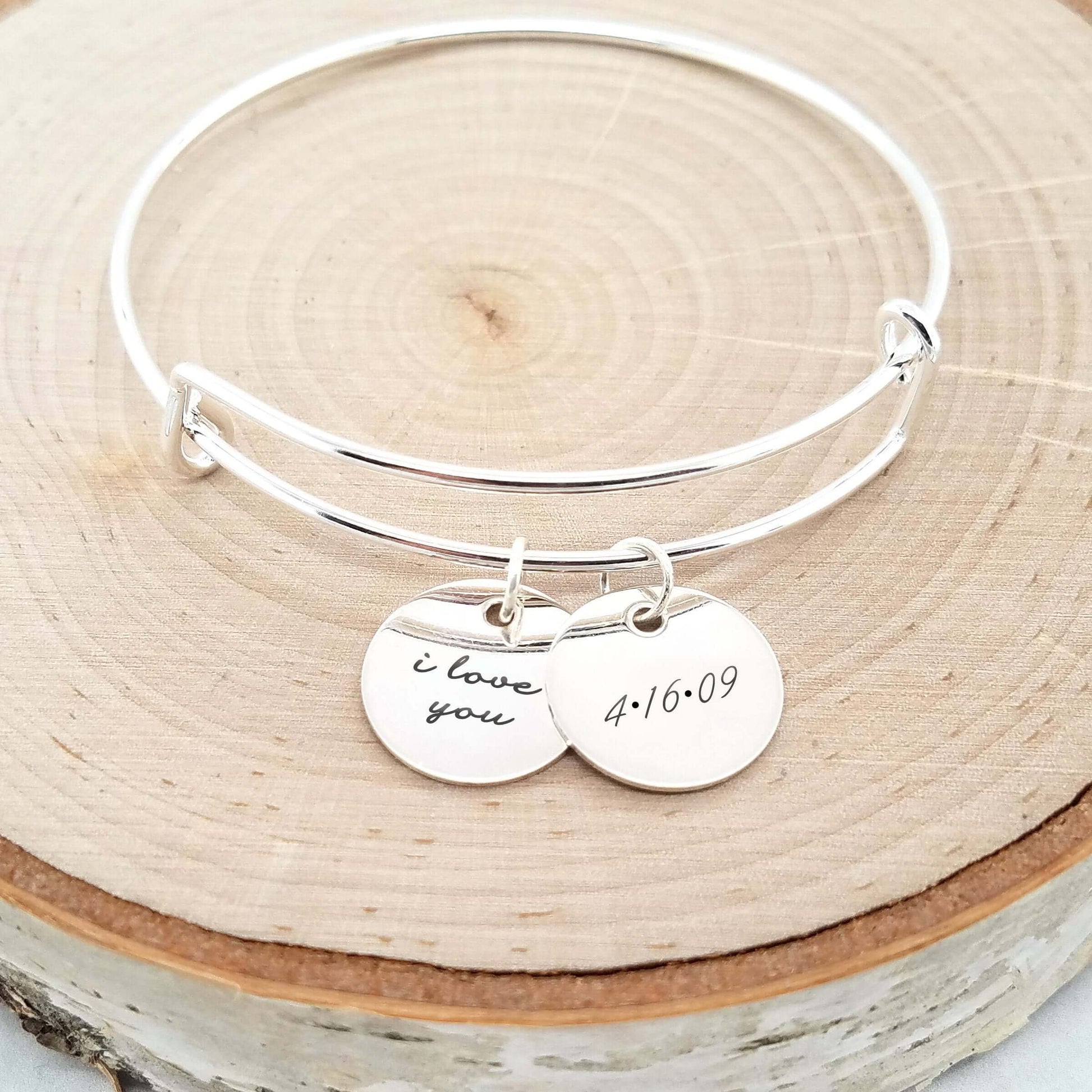 Personalized sterling silver anniversary bracelet with 'I love you' and date discs.