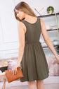 Model wearing a racerback tank dress in olive green, showcasing a flared silhouette and stylish design.