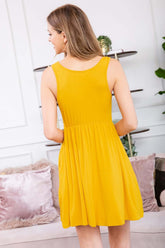 Back view of a yellow racerback tank dress featuring a flared silhouette and casual style.