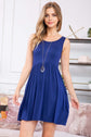 Model wearing a stylish navy racerback tank dress with a flared silhouette and on-seam pockets.