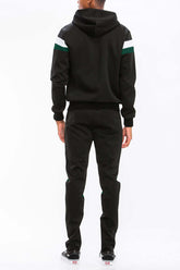Back view of a man in a chevron stripe color block full zip track suit with a hoodie and ankle zipper pants.