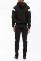 Back view of a man in a chevron stripe color block full zip track suit with a hoodie and ankle zipper pants.