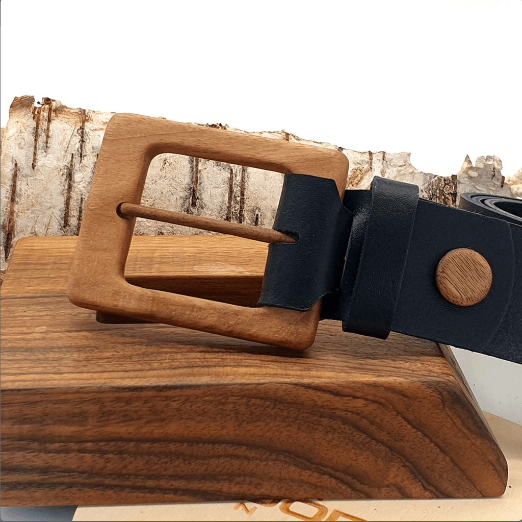 Luxury men's leather belt with walnut buckle on wooden display.