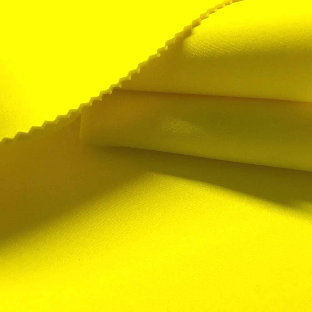 Vibrant yellow neoprene fabric showcasing smooth texture, ideal for fashion and design projects.