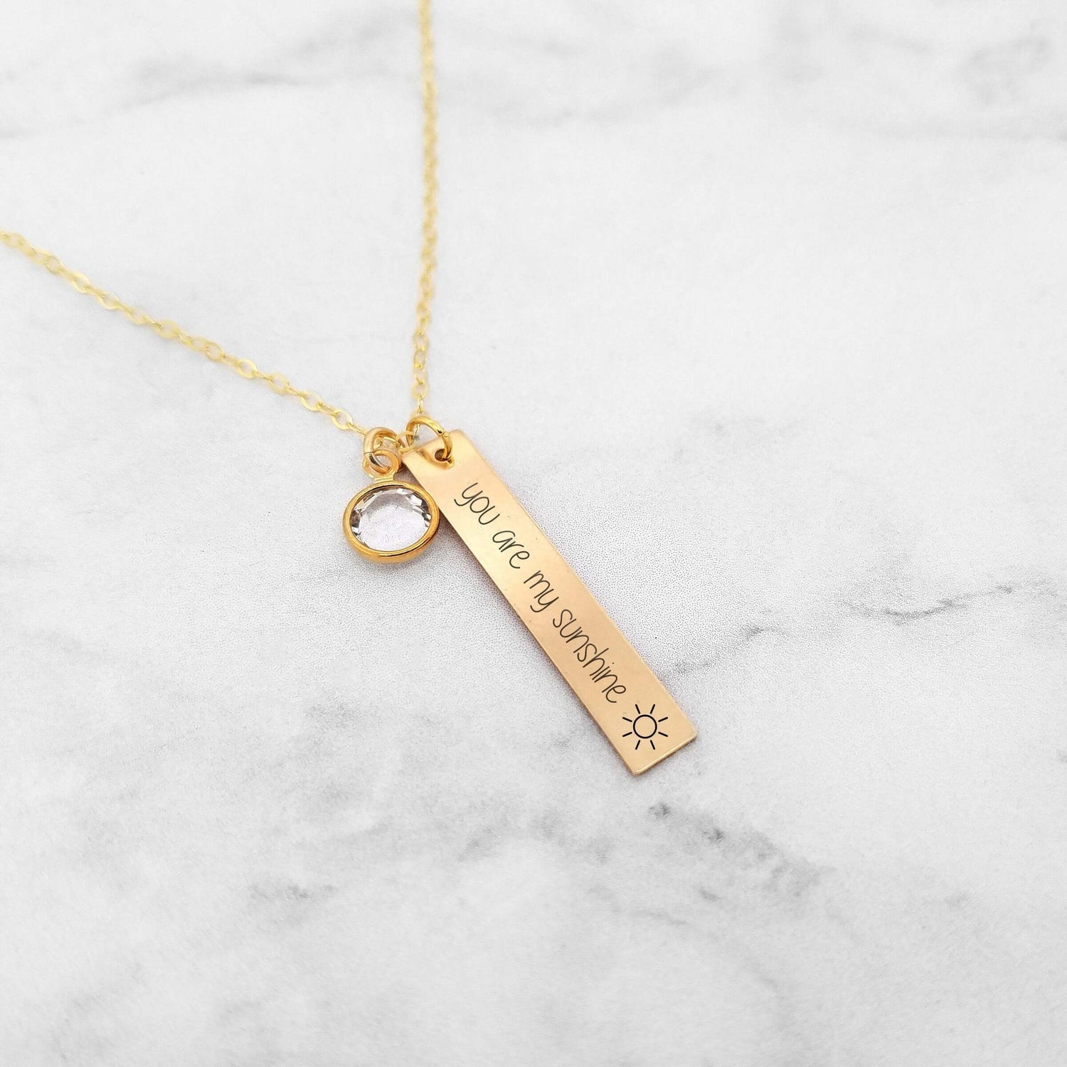 You Are My Sunshine personalized necklace with charm for mom or grandma on marble background.