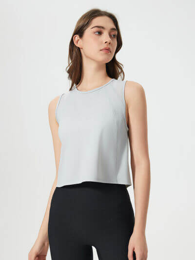 Model wearing a Millennia Round Neck Cropped Active Tank in light gray, featuring a basic style with a relaxed fit.