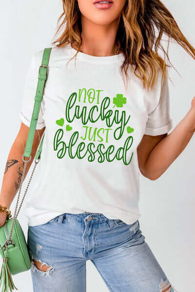 Model wearing 'Not Lucky Just Blessed' round neck t-shirt with green graphic design and casual outfit.