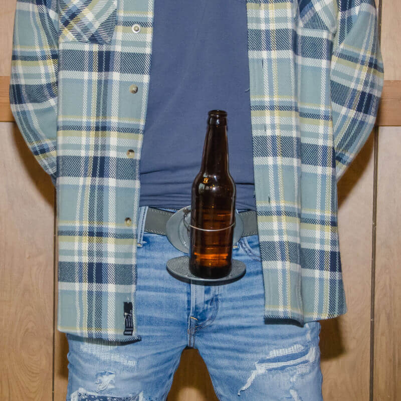 Person wearing a flannel shirt and jeans with a Cross BevBuckle holding a beer bottle at their waist.