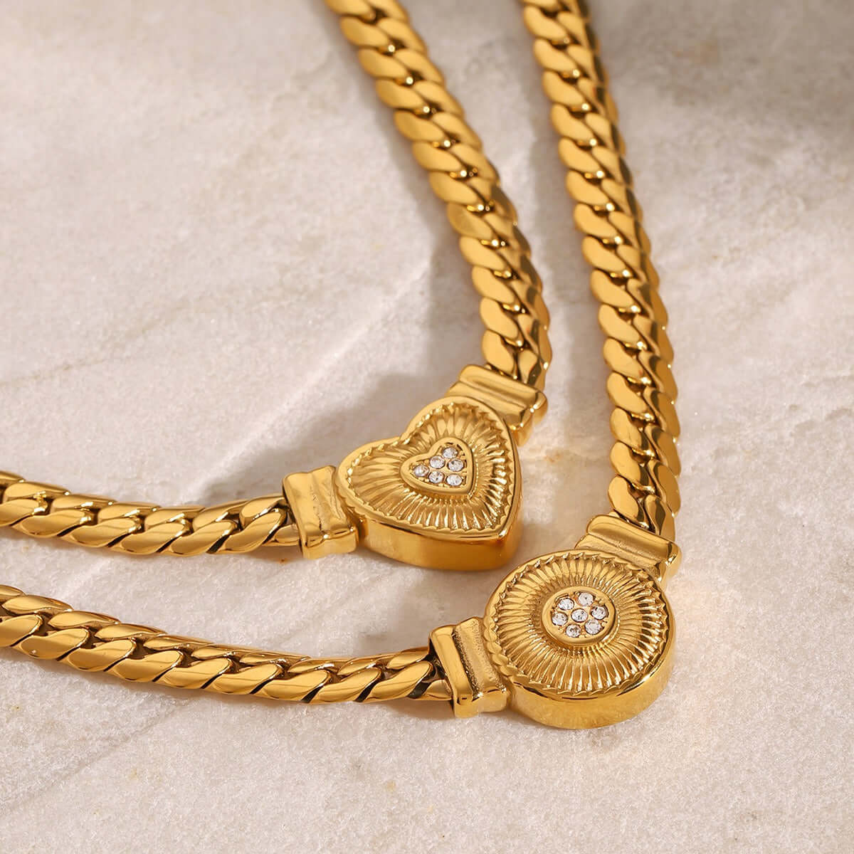 Luxury 18K gold-plated necklace featuring heart and round diamond-studded charms on textured chain.