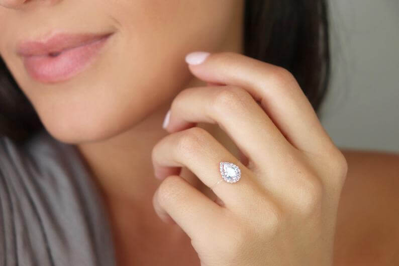 Model wearing a sterling silver floating pear-shaped ring with cubic zirconia, showcasing its elegant design.