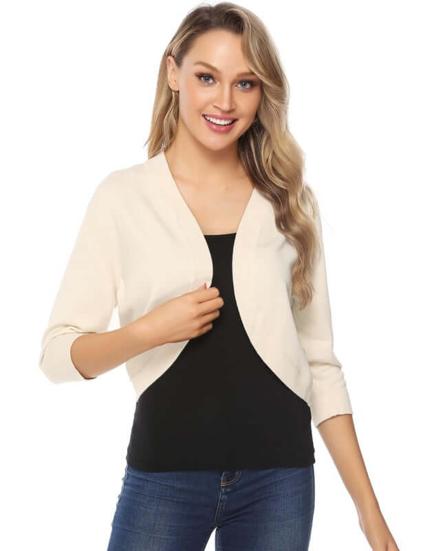 Smiling woman wearing a cream Women's 3/4 Sleeve Cropped Cardigan over a black top, highlighting layering style.