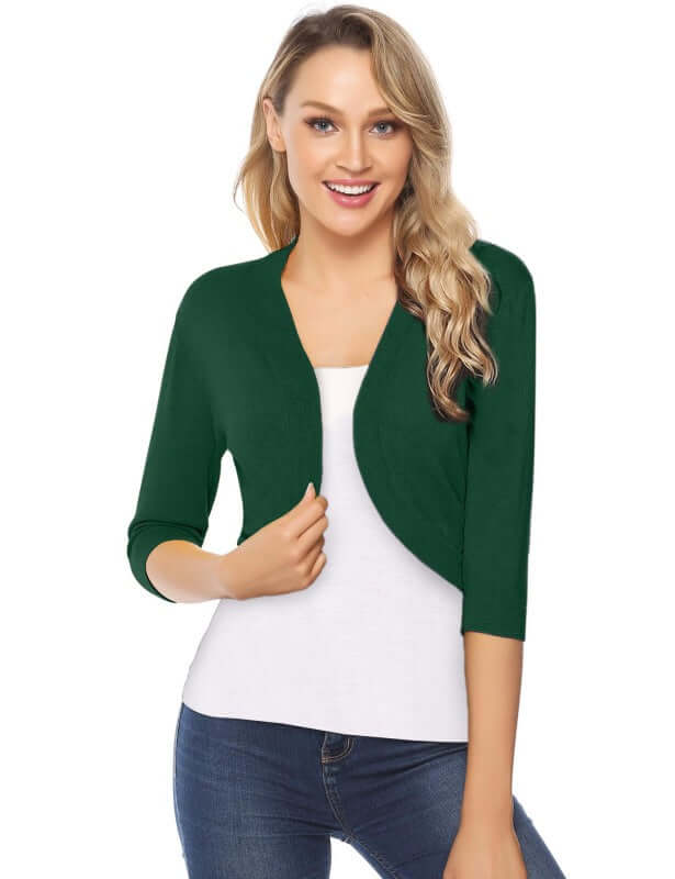 Woman wearing a green 3/4 sleeve cropped cardigan over a white top, showcasing a casual style.