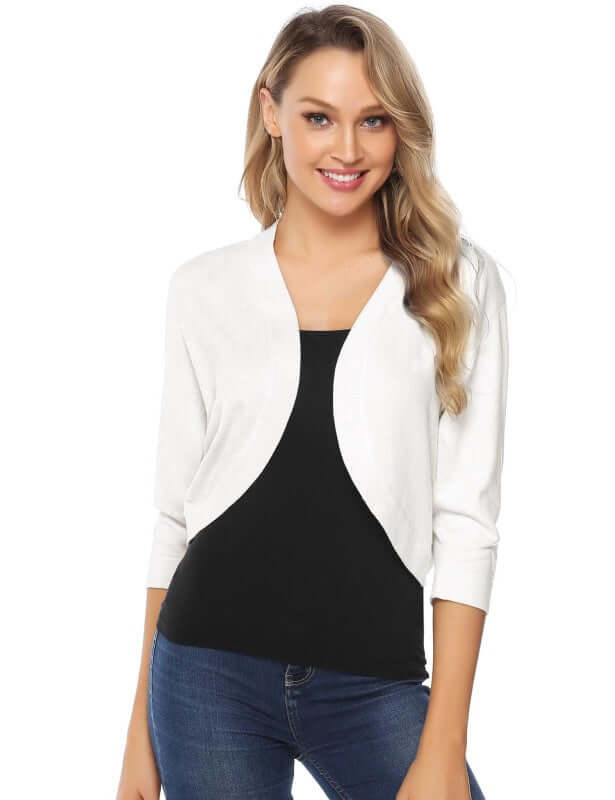 Woman wearing a white 3/4 sleeve cropped cardigan over a black top, showcasing a stylish leisure look.