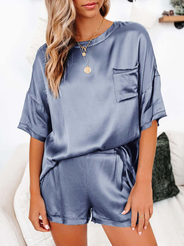 Women's short-sleeved satin pajamas set in blue with pocket and relaxed fit for home comfort.