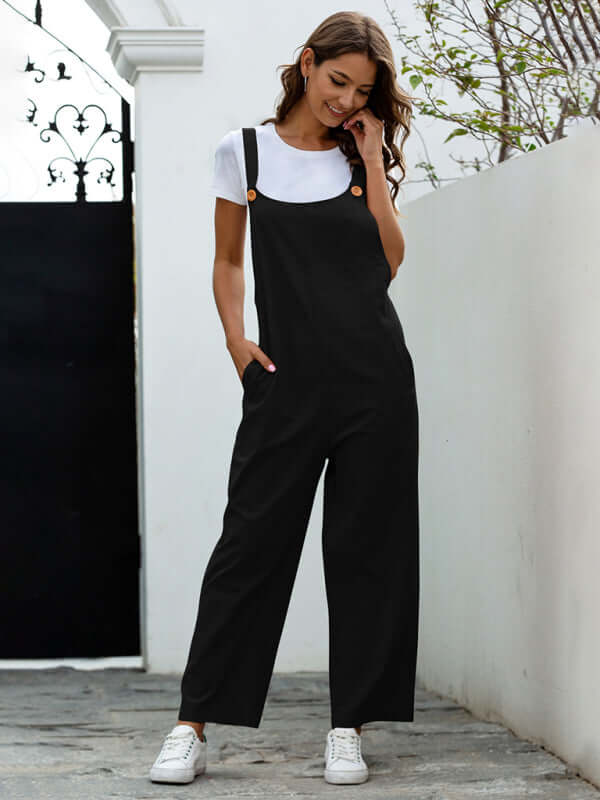 Stylish woman in black woven retro casual long overalls with slant pockets and a square collar, paired with a white tee.