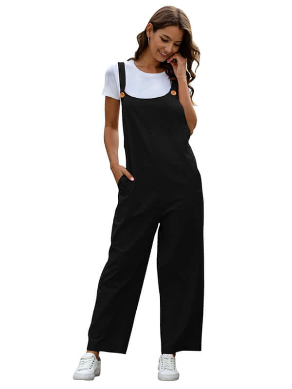 Woman wearing black woven retro casual long overalls with slant pockets, paired with a white t-shirt and sneakers.