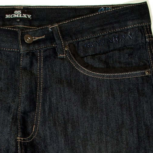 Close-up of 65 McMlxv men's premium dark wash denim jeans featuring logo embroidery and classic straight-leg design.