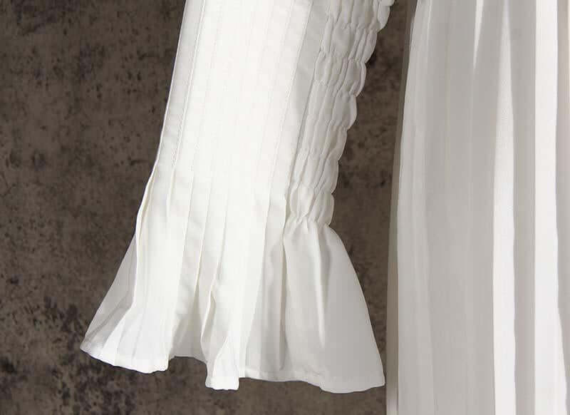 Close-up of the pleated sleeve of a white cotton long sleeve shirt dress, showcasing its casual and stylish design.