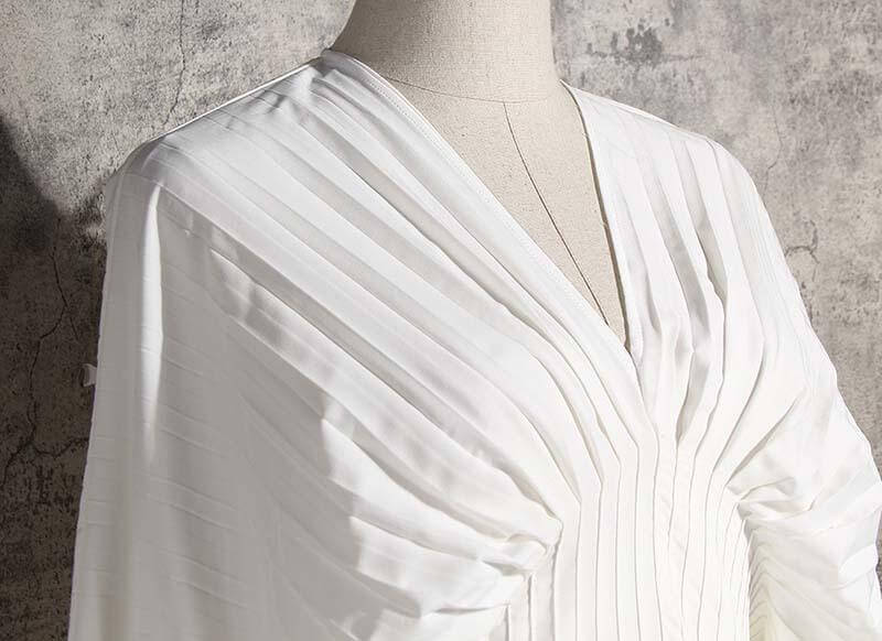 Sakiya pleated long sleeve shirt dress in white showcasing V-neck and stylish pleats, perfect for casual occasions.